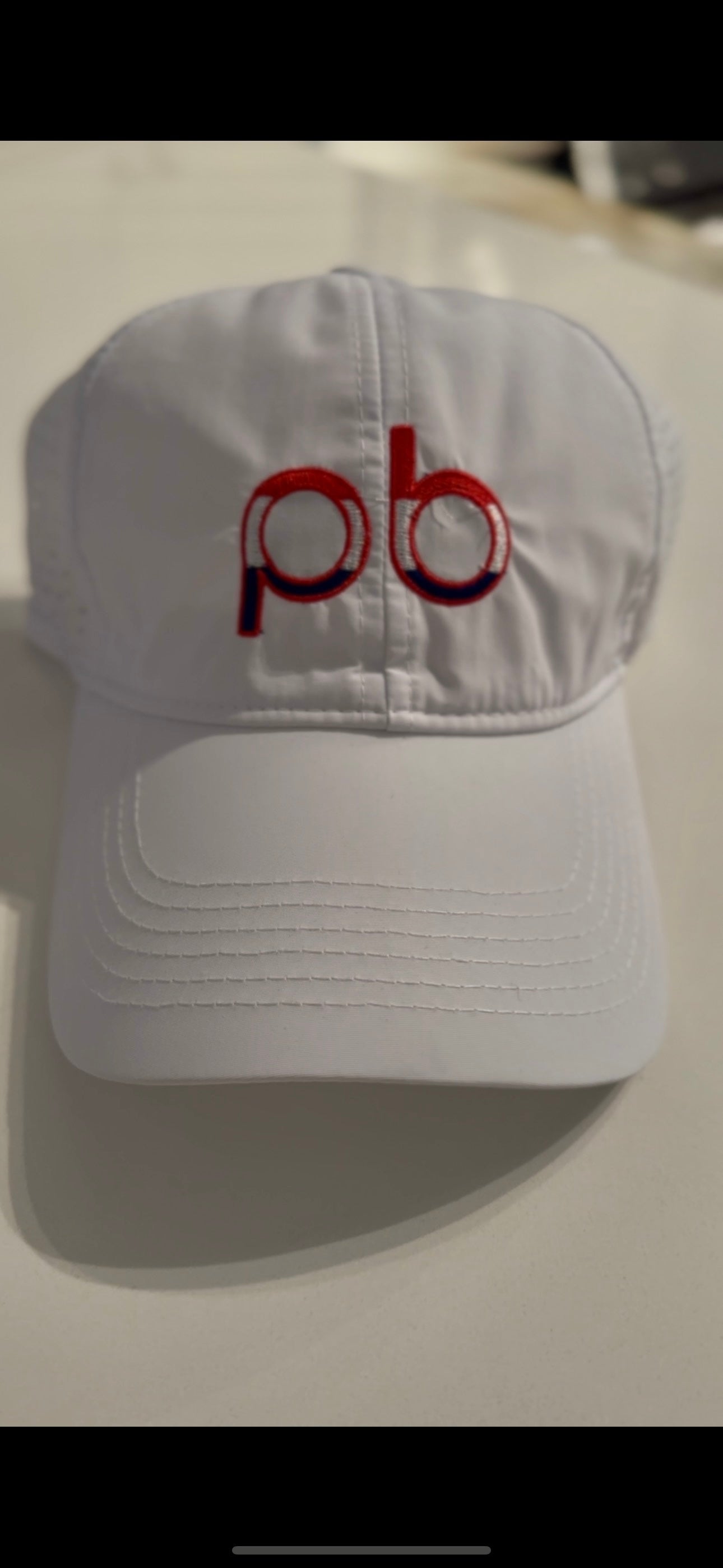 White Athletic hat with red, white & blue "pb" logo
